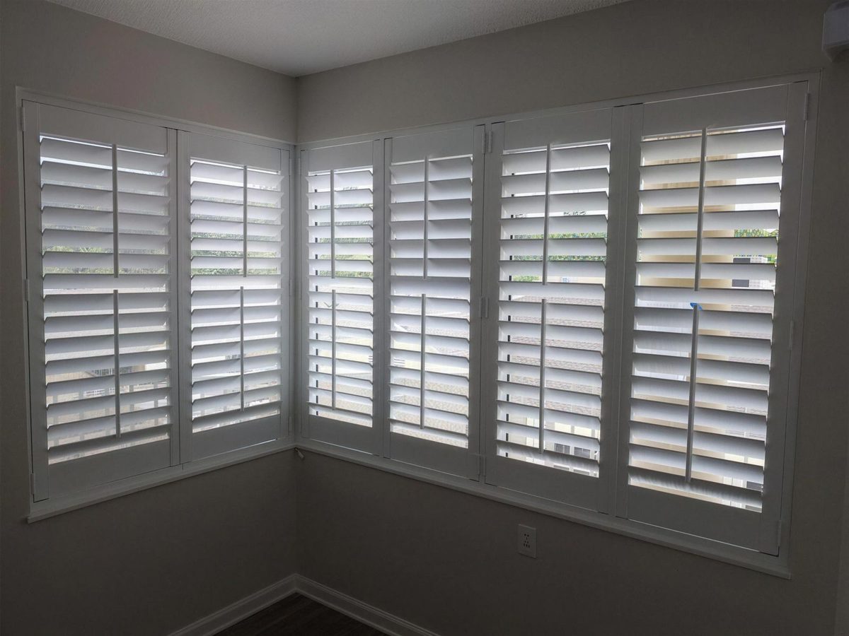 Corner windows fitted with custom white plantation shutters